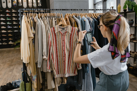 Woman taking photos of clothes in her boutique for marketing purposes.